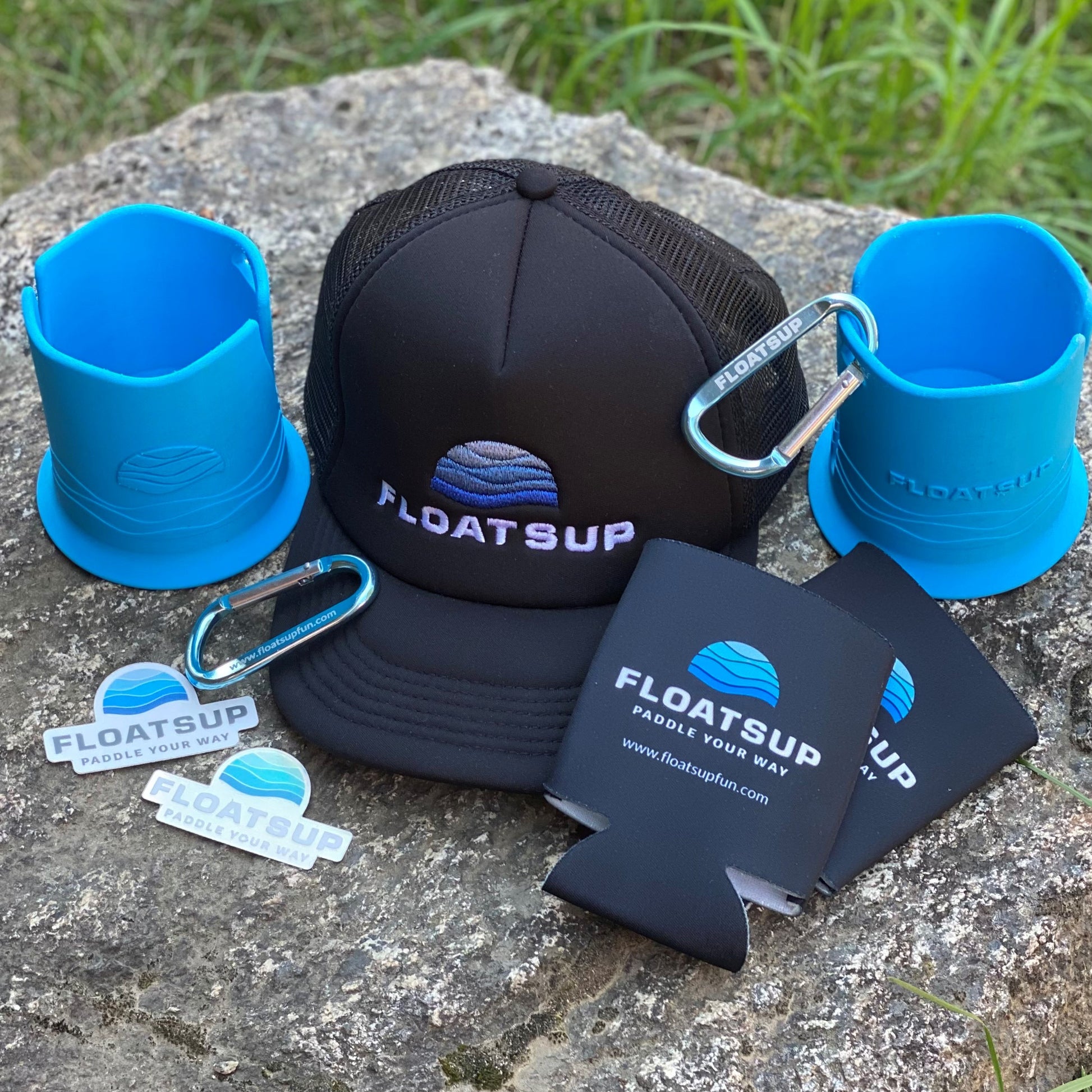 A group of Floatsup branded items including hat, Floatsup Cup, coozies, and Floatsup logo stickers.